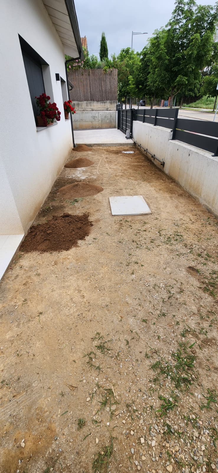 Pas lateral de casa amb terra i sauló abans de la reforma a Osona