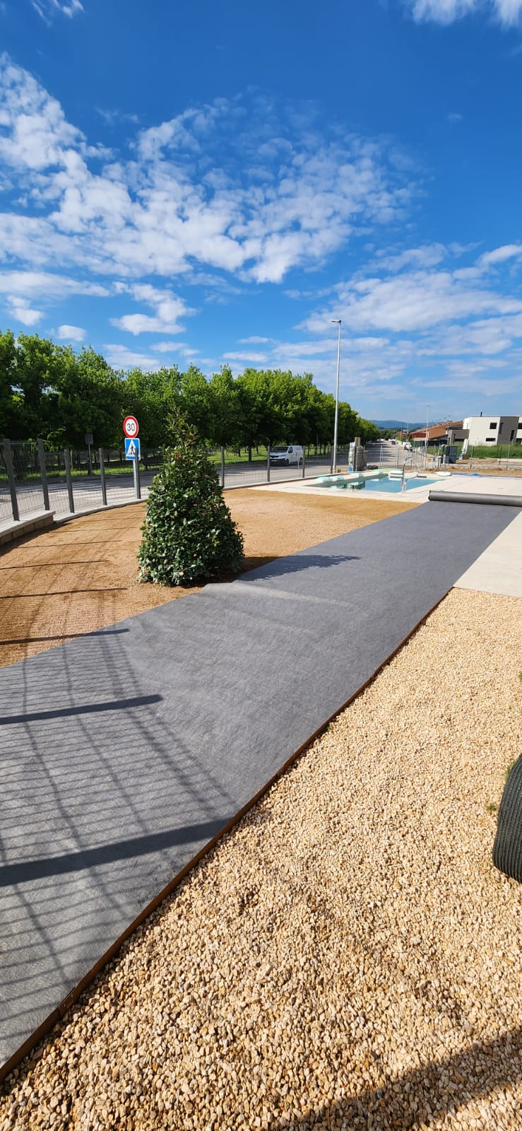 Jardí amb gespa artificial instal·lada i arbre central a Osona