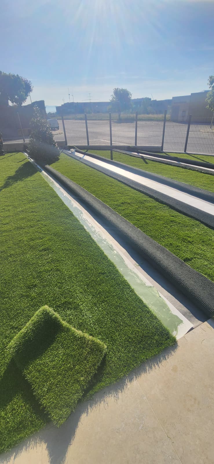 Gespa artificial i grava al voltant de piscina exterior a Osona