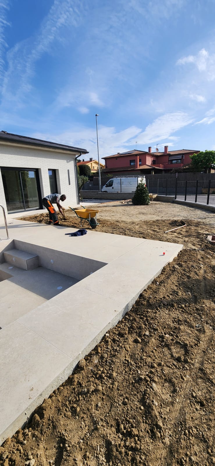 Preparació del terreny per a instal·lació de gespa artificial al costat de piscina a Osona
